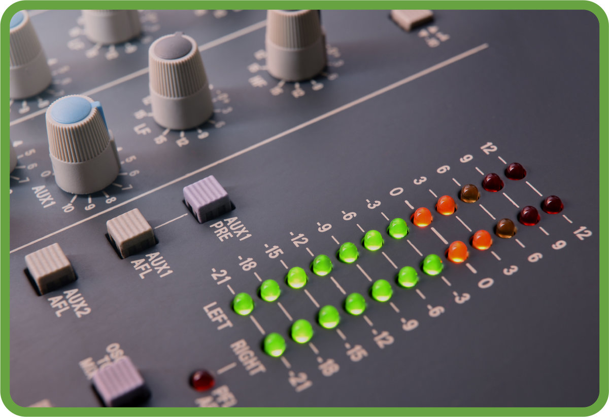 Two vertical rows of green and orange lights are illuminated on an audio reference meter.